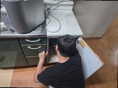 동안구 누수탐지 싱크대 하부장과 벽면의 누수 흔적을 확인하는 모습