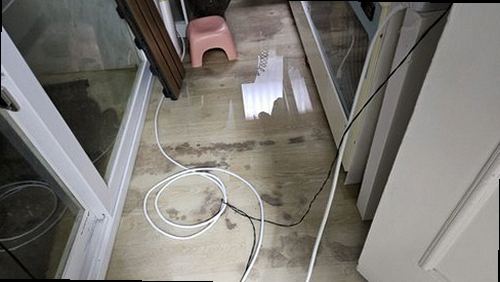 연천 누수탐지 베란다 창틀과 바닥 배수구 주변의 누수 흔적을 확인하는 모습
